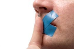 Censored Man with blue tape on his mouth. Finger before lips. Isolated on white.
