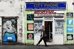 BRISTOL, UK - OCT 31, 2015: View of a mobile phone and computer repair shop decorated by street art. The west country city is famous for its vibrant graffiti and street art.