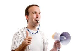 Horizontal view of a team coach blowing his whistle and giving a thumbs up, isolated against a white background