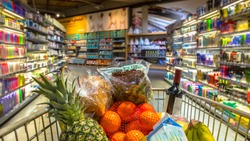 Easter shopping Grocery cart at a colorful supermarket filled up with food products as seen from the customers point of view