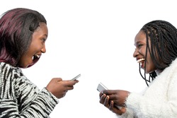 Close up portrait of happy african teen girls laughing with smart phones. Isolated on white background.