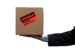 Man holding a cardboard moving box with a orange fragile sticker on a white background