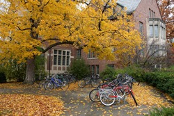 Fall College Campus. University student dorm with autumn leaves and bike racks. Horizontal format.