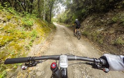 POV, Original point of view. Pair of man on mountain bike in a mountainous road.