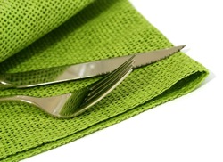 knife and fork with green napkin isolated on white background