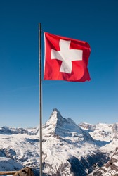 A mountaintop view of the national flag of Switzerland with the Matterhorn in the background