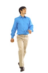 A young businessman is walking. He is smiling and looking away from the camera isolated over white background