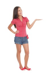 Showing product in full length. Young beautiful casual college student holding her arm out and presenting your product with open hand. Gorgeous mixed race chinese / caucasian model isolated on white.