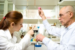 professor and his assistant in the chemical laboratory conducting experiments