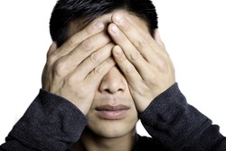 Man Holding hands over eyes copying the common phrase see no evil, hear no evil, speak no evil