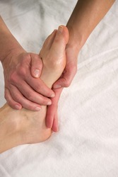 closeup of a foot of a natural mature woman having a massage at the sole of her foot
