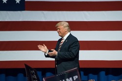 ASTON, PA - SEPTEMBER 22, 2016: Donald Trump enters the stage and walks by the American Flag. Trump is the Republican nominee for US President and he held a rally at Sun Center Studios.