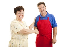 Mature lady shopping, shaking hands with a sales clerk or other type of worker. Isolated on white.