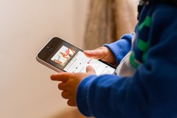 Orvieto, Italy - October 15th 2016: Baby watching a video from Youtube on Apple Iphone. Close up of hands