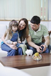 young parrent at home with beautiful child make savings and put coins money in piggy bank