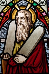 Detail of English, Victorian stained glass church window depicting Moses with the tablets of covenant in his arms, interestingly without text, means he is pictured before climbing Mount Sinai