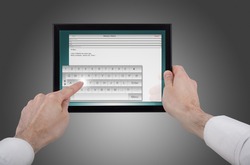 a male hand holding a touchpad pc, one finger touches the screen and writes an e-mail