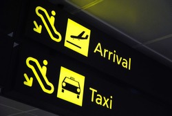 Arrival and taxi signages at the airport for concepts related to travel and transportation, aviation and airport, and vacation.