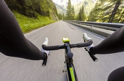Cyclist Going dowun on mountainous road. Cycling in Dolomites, Passo Falzarego. POV Original point of view