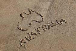 Australia Map and word drawn in the sand at the beach on an angle. Australia's beaches are one of its iconic drawcards.