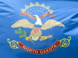 A close-up of the North Dakota state flag waving in the wind.