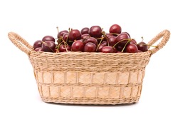 Red cherries in wooden basket isolated on white