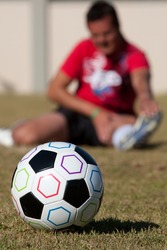 Football with man stretching in background