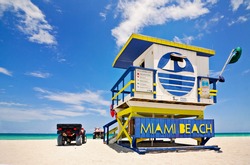 Summer scene with a typical colorful lifeguard house in Miami Beach, Florida with blue sky and ocean in the background