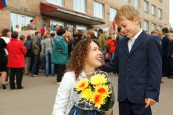 First class, a boy and his mother a bouquet of flowers stood at the entrance to the school.