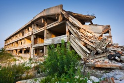 Landscape of ruined buildings at sunset, image of decrepitude or natural disaster
