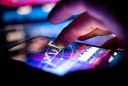 A businessman checking stock charts on a mobile device. Technology and work on the go.