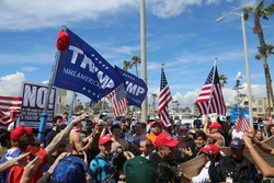 Huntington Beach, CA - March 25 2017: Make America Great Again March. Supporters and protesters of republican president Donald Trump, wave flags, and hold signs at a MAGA March in Huntington Beach.