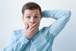 Caucasian, young man is worried and shicked because of sweating stain. problem with hyperhidrosis