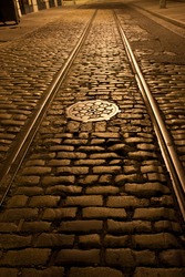 Old trolley tracks and cobblestones survive under the flaking asphalt pavement of this Brooklyn Heights street, Brooklyn, New York. A night time exposure.