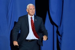 HARRISBURG, PA - APRIL 29, 2017: Vice President Mike Pence "bursts" through the opening on stage at a Trump campaign rally marking 100 days in office. Held at the Farm Show Complex and Expo Center.