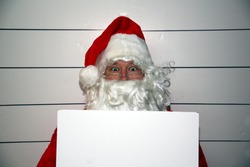 Santa Claus Mugshot. Santa holds a blank white booking sign while his mugshot is taken. Booking Sign is blank for your text.