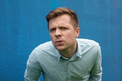 I don't know. Portrait of doubtful caucasian male wearing casual blue shirt, looking with indecisive expression on his face, showing doubt and hesitation. Body language