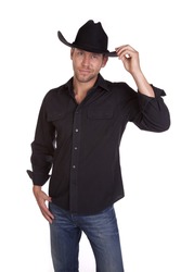 A cowboy in his black shirt and hat showing his small smile and touching his hat.