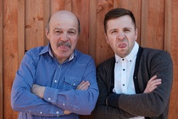 Young and old men show their tongue, fooling around. Funny family portrait.