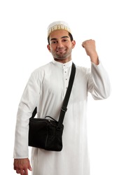 An ethnic arab or south asian man dressed in traditional cultural clothing. He is smiling and one arm clenched in a victory fist of success