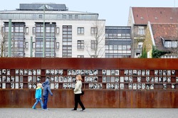 Berlin, Germany - April 12, 2017: Monument of the Berlin Wall with photos of people and visitors.