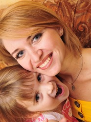 Beautiful portrait of happy cheerful mother with little daughter in embrace
