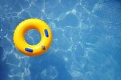 Yellow pool float, pool ring in cool blue refreshing blue pool, room for your text