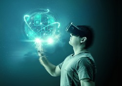 A young man wearing virtual reality (VR) goggles and headset with a projection of a digital world.