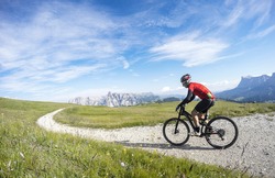 Cycling in Trentino Alto Adige on summer season. Enjoying a bike ride in Dolomites region mountains.