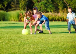 Group of happy preschool kids catching the ball