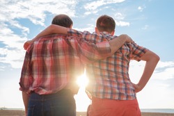adult father and son holding hands at sunset. Good relationships between generations