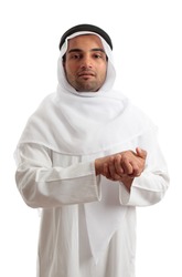 An ethnic man dressed in arab , saudi or other middle eastern attire. He is wearing a white robe, ghutra and igal. White background.