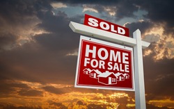 Red Sold Home For Sale Real Estate Sign Over Beautiful Clouds and Sunset Sky.