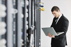 young it engeneer business man with thin modern aluminium laptop in network server room